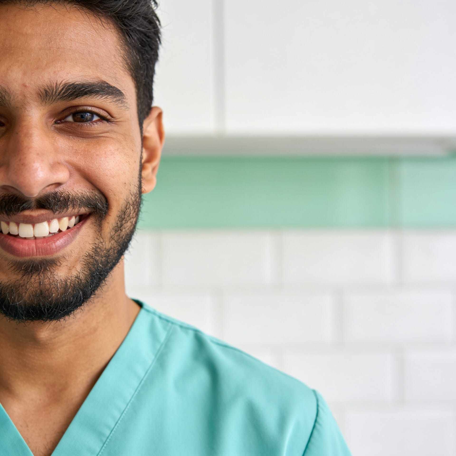 Portrait of Sam Patel smiling in mint scrubs